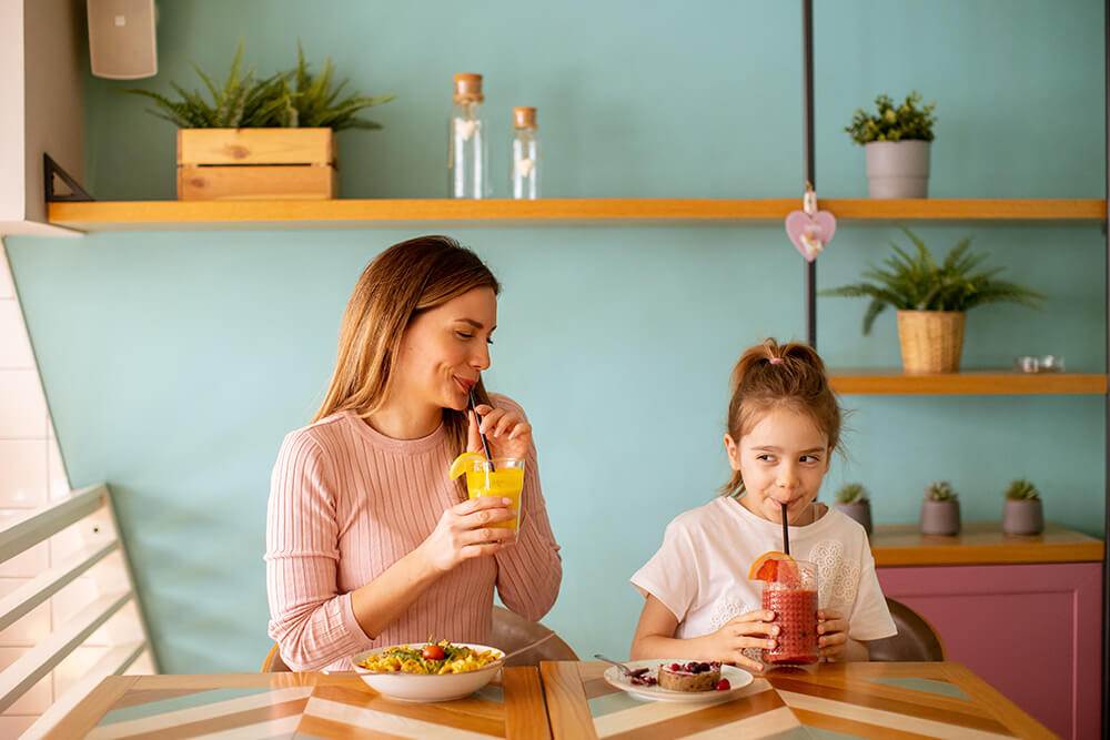 Madre e hija tomando jugo de frutas